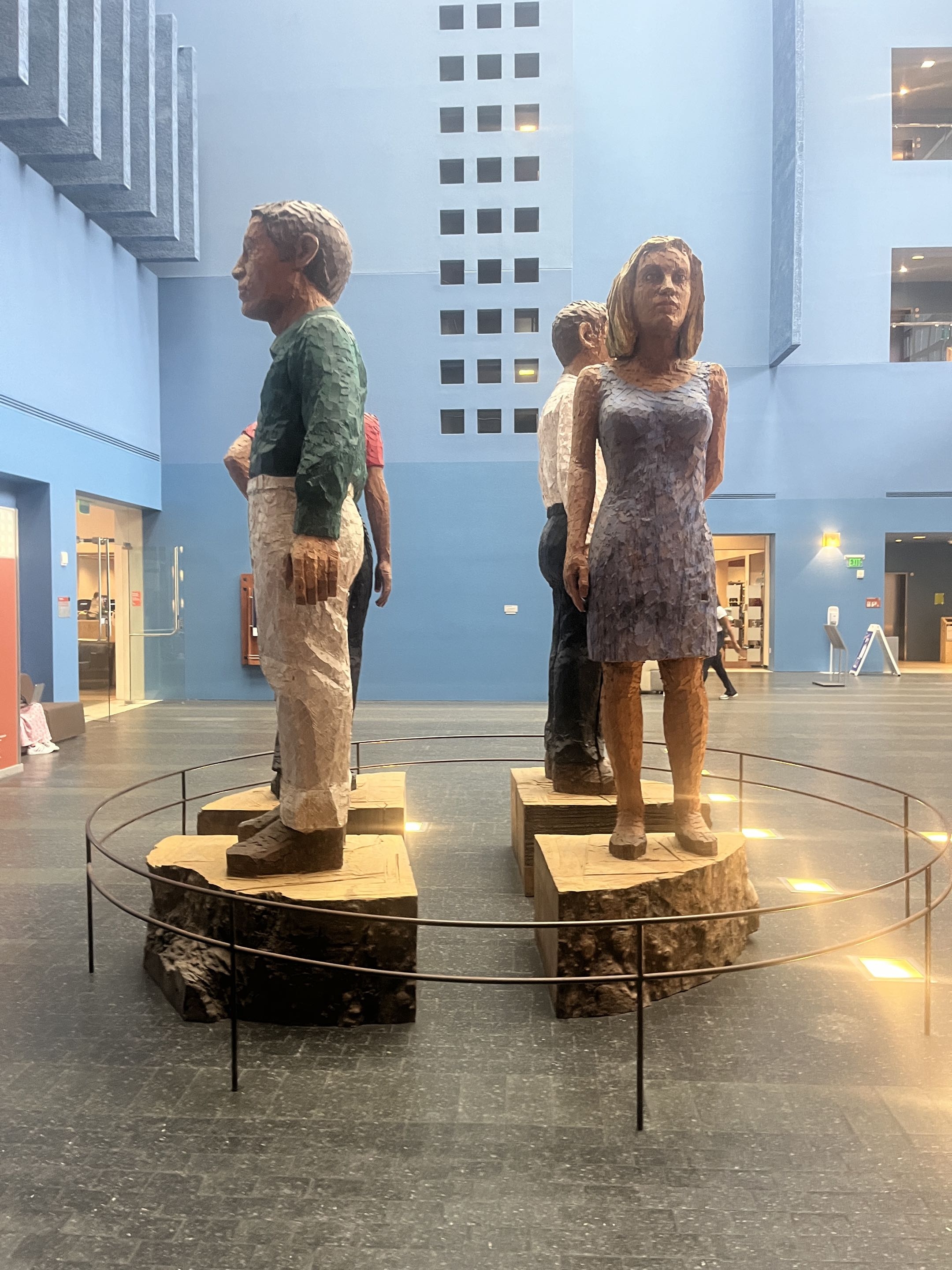 Large carved wood figures in UCSF Fisher Atrium